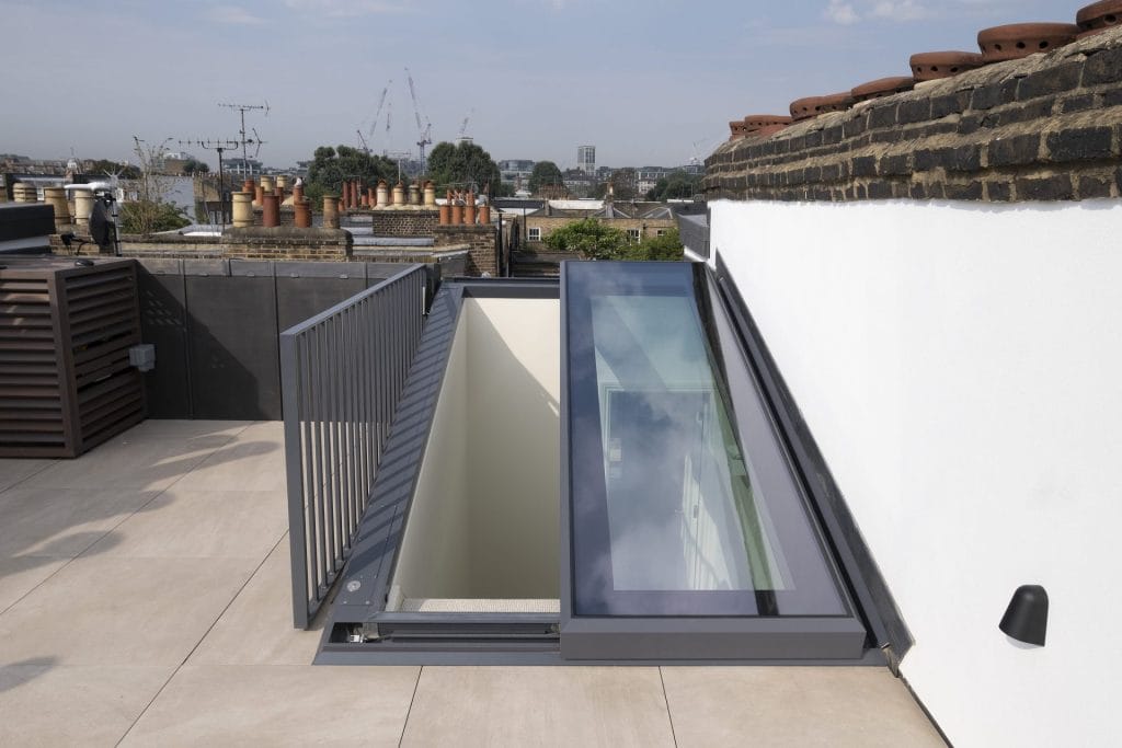 A modern sliding over fixed glass rooflight providing seamless access to a rooftop terrace while maximising natural light